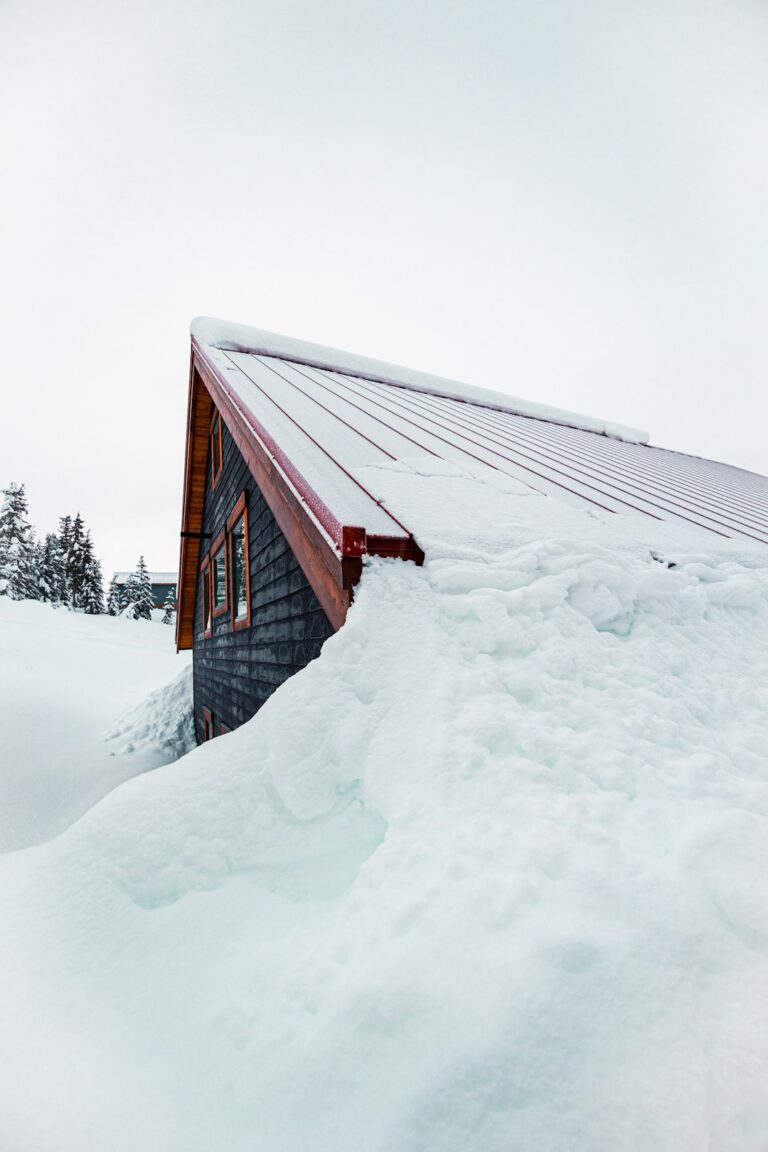 Snow-covered roof with thick ice buildup along the eaves and icicles hanging over a gutter.